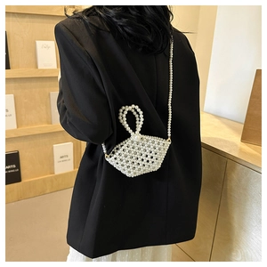 Macro detail of handmade white pearl woven mini bag with circular handle and crossbody strap