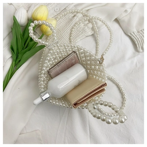 Detail of white pearl beaded handbag showing storage space for wallet and cosmetics