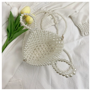 Detail of handmade pearl bucket bag with woven beads, handle and detachable strap