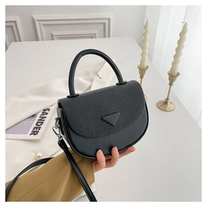 Detail der schwarzen Halbrundtasche mit gewebter Klappe und Metallic-Dreieckslogo
