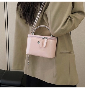 Close-up of pink patent leather mini box bag with silver metal handle and chain strap
