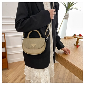 Detail der minimalistischen beige Tasche mit gewebter Klappe und glattem Griff
