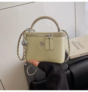 Detail of light green patent leather mini box bag with silver flower hardware and handle