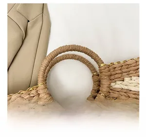 Dettaglio del manico rotondo in paglia e trama intrecciata beige e marrone con cuciture