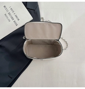 Detail view of mini crossbody box bag showing herringbone lining and internal capacity