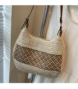 Detail der handgeflochtenen Strohtasche mit zweifarbiger Textur und Leder-Schultergurt