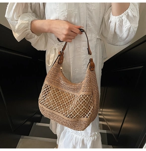 Detail der handgewebten Strohtasche mit Netzhaut-Design und braunem Ledergriff