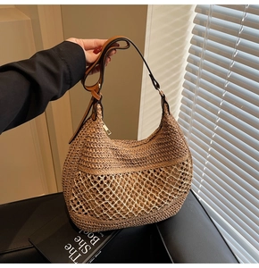 Detail der handgewebten Strohtasche mit beigem Netzdekor und braunem Lederriemen