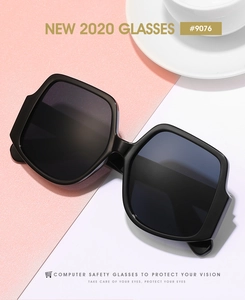 Detail view of irregular large frame black sunglasses with tinted lenses on desk