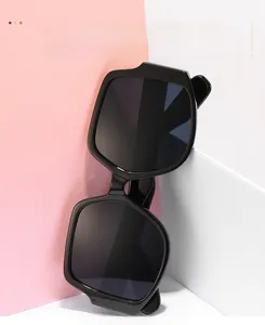 Detail shot of irregular oversized black sunglasses with gray polarized lenses