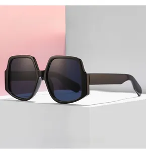 Macro shot of oversized irregular hexagonal sunglasses with blue lenses on a white block
