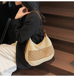 Detail der minimalistischen Stroh-Hobo-Tasche mit Hohlgeflecht und braunem Lederriemen