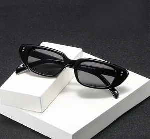Details schwarzer Cat-Eye-Sonnenbrille mit silbernen Nieten und polierter Textur auf Ständer