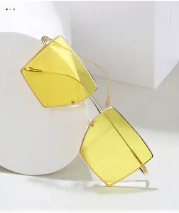 Detail of square gold metal sunglasses with fashion yellow gradient lenses on white props