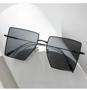 Detail of square black metal sunglasses with geometric lenses on a modern white pedestal