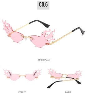 Détail de lunettes de soleil sans monture en forme de flamme rose avec branches dorées