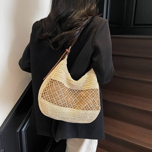 Große Strohtasche mit braunem Lederriemen und hohlem Netzdesign für den Strandurlaub