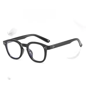 Détail de la monture de lunettes ronde noire rétro avec rivets argentés et verres anti-bleu