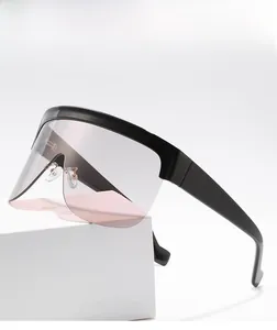 Detail of oversized shield sunglasses featuring pink gradient lenses and black frames