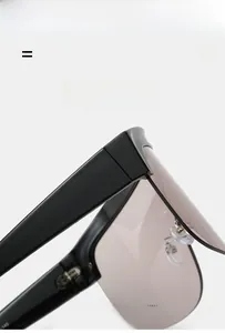 Detail of glossy black lightweight sunglasses showing flexible hinges and gradient lenses