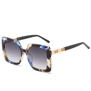 Schicke quadratische Sonnenbrille mit buntem Patchwork-Design und goldenen Metallbügeln