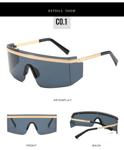 Détails de lunettes de soleil oversize avec garniture en métal doré et verres gris foncé