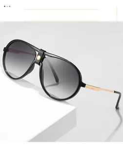 Detail of aviator sunglasses with black frames, gradient lenses, and gold metal temples