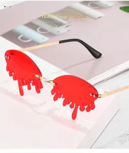 Detailed close-up of red melting tear-shaped lenses with gold metal accents
