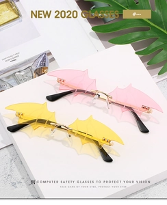 Macro detail of rimless bat-shaped sunglasses with pink and yellow gradient lenses