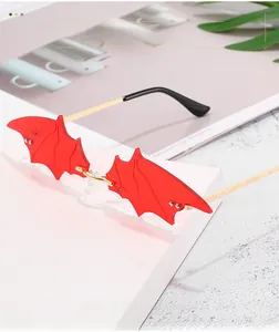 Detail of red bat-shaped sunglasses with silver rivets and gold metal temples