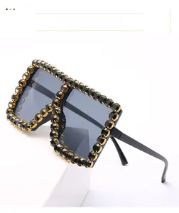 Detail of luxury oversized square sunglasses with black rhinestones and gold metal base
