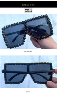 Detail view of large square sunglasses featuring black crystal rhinestones on frames