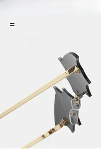 Detail of bat-shaped rimless sunglasses featuring golden metal temples and dark grey lenses