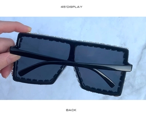Detail view of oversized square sunglasses with sparkling rhinestones on the black frame