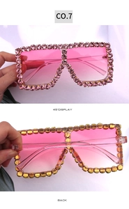 Detail of square sunglasses with pink rhinestones and gradient lenses from 45 degree angle