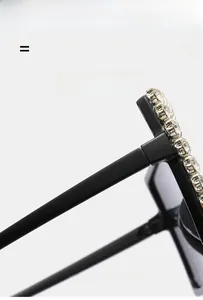 Detail of oversized black sunglasses with sparkling rhinestones on the top frame