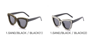 Detailed view of cat-eye sunglasses featuring luxury rhinestone frames and dark lenses
