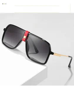Detail of square oversized sunglasses with red leather accent and gold metal temples