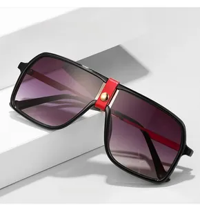 Detail of square oversized sunglasses with red leather bridge and gold stud accent