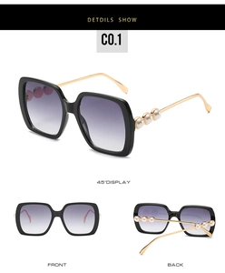 Detail of oversized sunglasses with pearl-embellished gold temples and gradient lenses