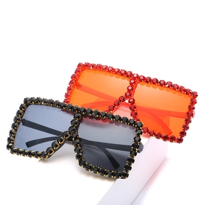 Oversized square sunglasses with rhinestones in black and orange on a white display