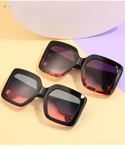 Dettaglio di occhiali da sole squadrati oversize in tartaruga e nero con lenti sfumate