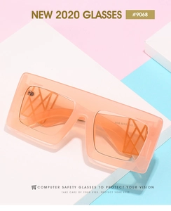 Detail of oversized square sunglasses featuring translucent orange frame and textured temples