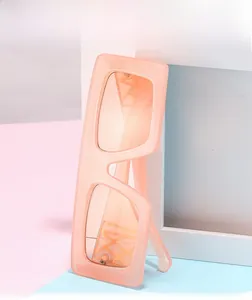 Detail of peach pink oversized square sunglasses with matte semi-transparent frame
