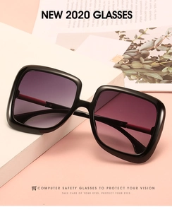 Detail of square oversized sunglasses with purple gradient lenses on a white display