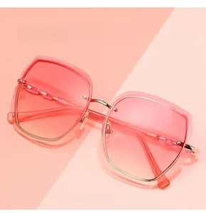 Detail of rimless gradient pink lenses with golden metal bridges and chain deco temples