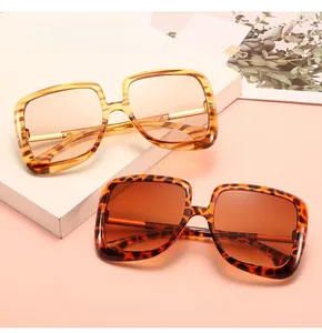 Detail view of square oversized sunglasses with leopard patterns and gradient lenses