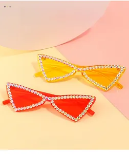 Détail de lunettes de soleil œil-de-chat sans monture avec strass en rouge et jaune