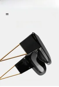 Detail of sleek black cat-eye sunglasses featuring slim gold metal hinges and temples