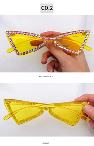 Détail de lunettes œil-de-chat sans monture avec verres jaunes et strass brillants